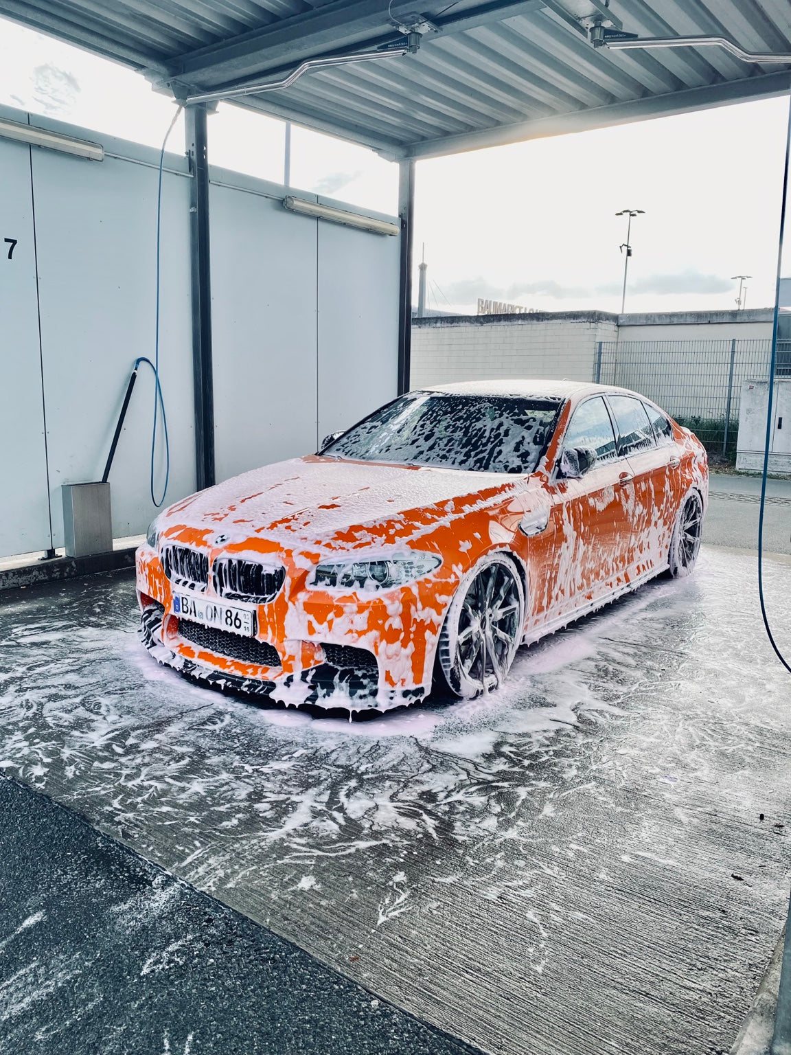BMW M5 Fire Orange während der gründlichen Handwäsche