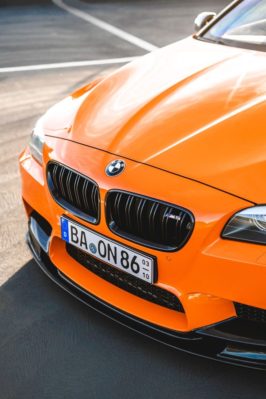 Glänzender Lack an der Front eines BMW M5 Fire Orange